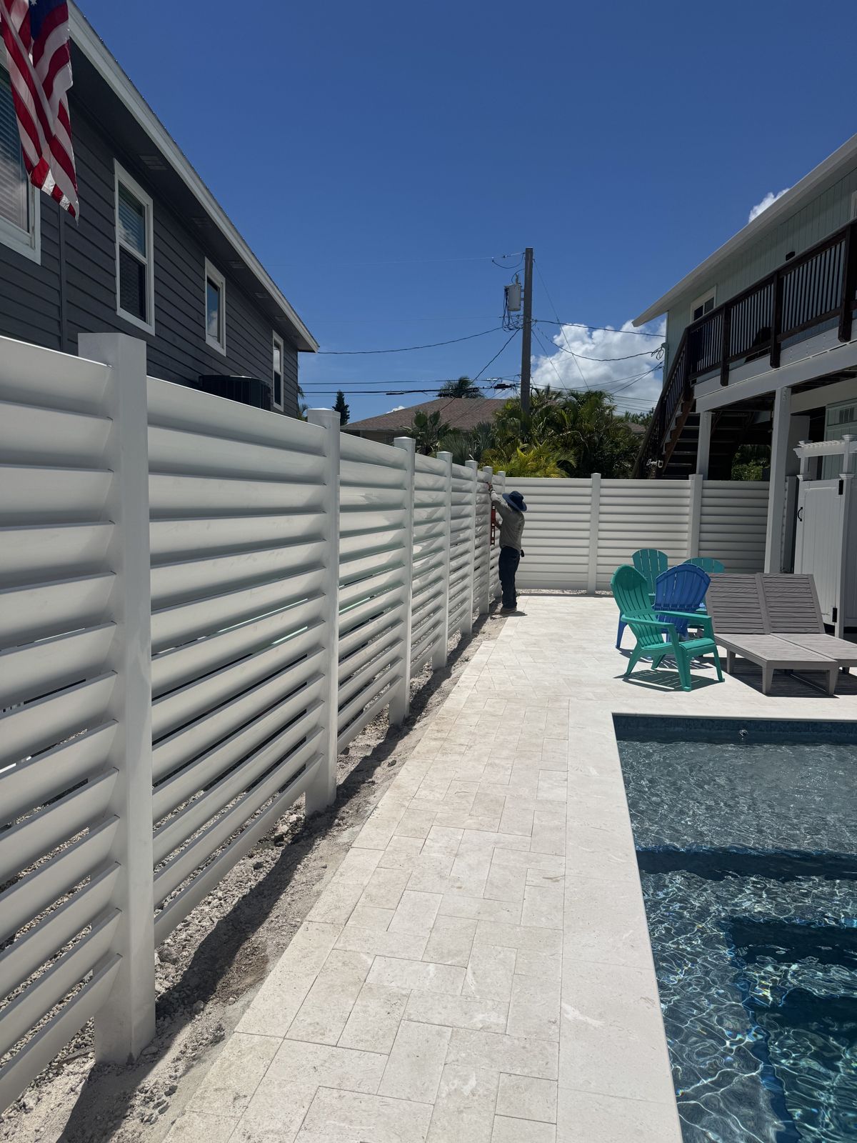 White louvered PVC privacy fence around a backyard pool in the Florida Keys