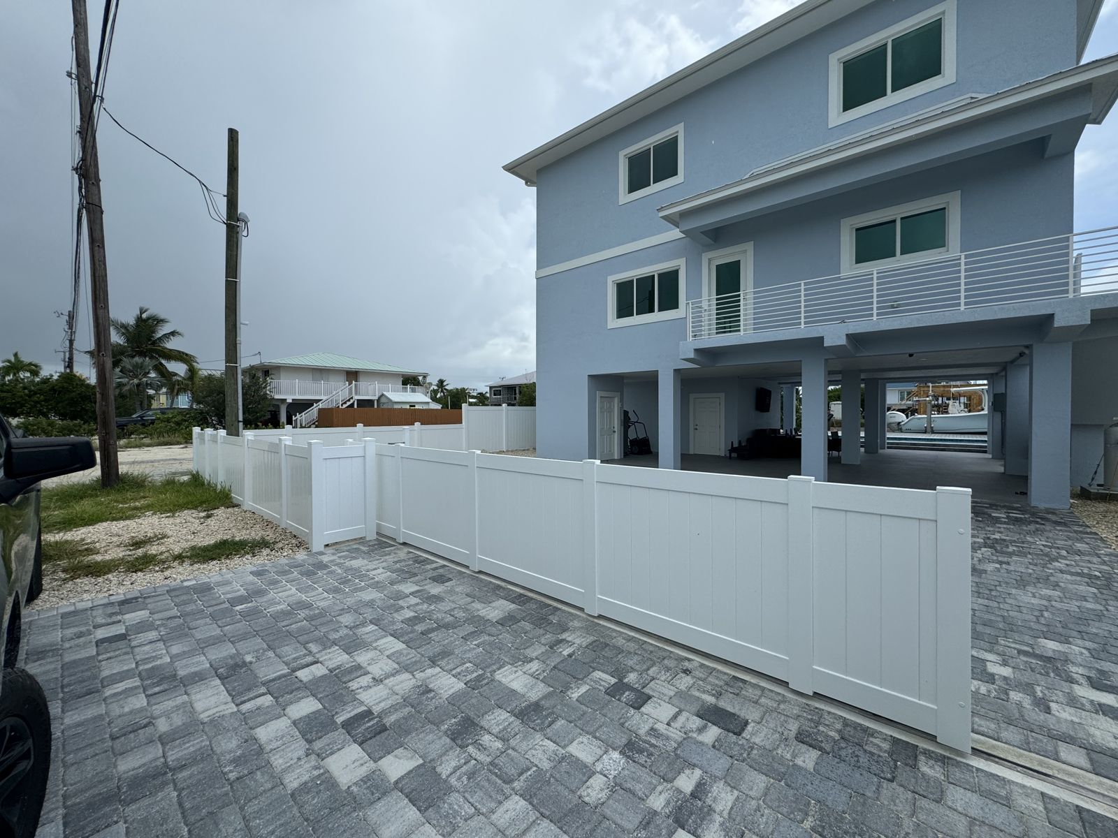 White PVC privacy fence with a matching driveway gate at a Keys home